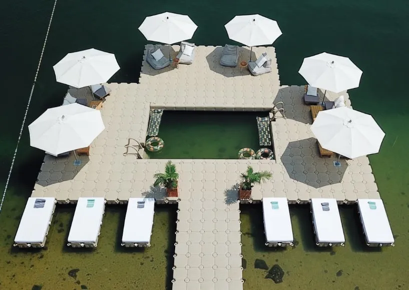 Solárium flotante con sombrillas y reposeras