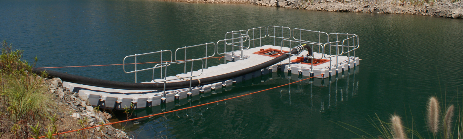 Plataforma flotante industrial Candock con barandas sobre un embalse
