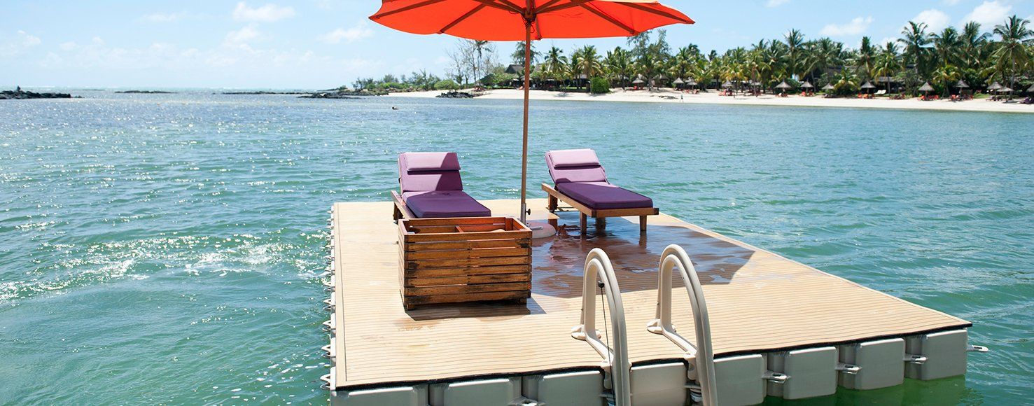 Plataforma flotante Candock con reposeras, sombrilla y escalera en el mar