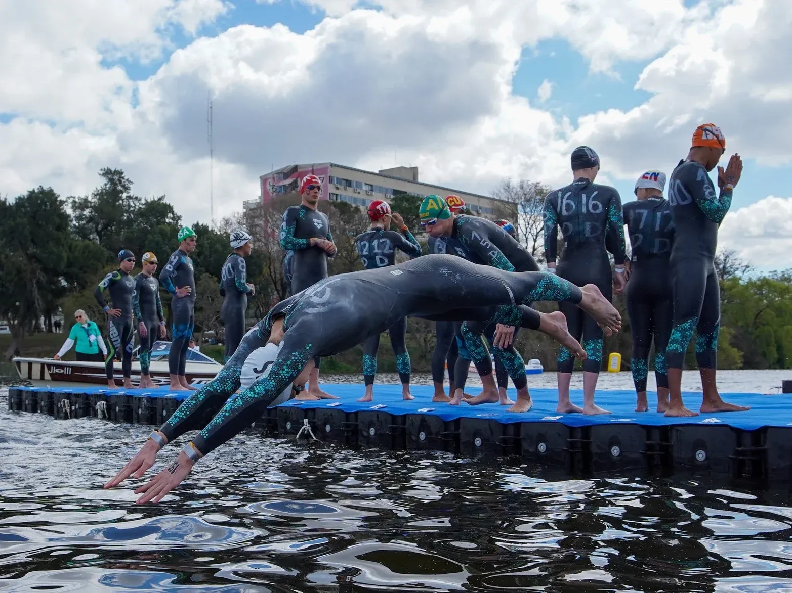 Triatletas lanzándose al agua desde una plataforma flotante Candock